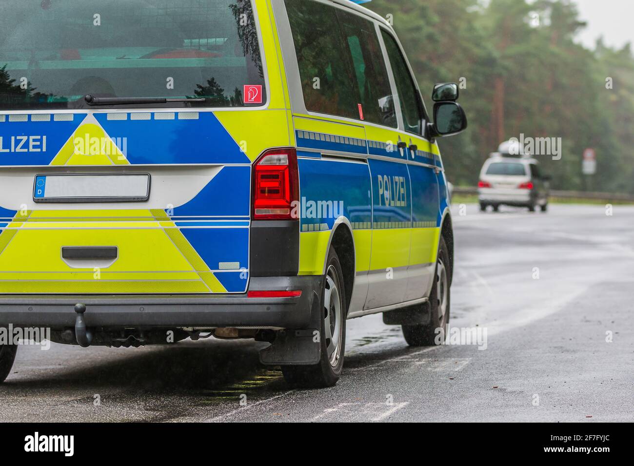 Vue partielle d'une voiture de police allemande sur l'autoroute par temps pluvieux. Côté passager du véhicule avec le lettrage police sur la carrosserie en bleu Banque D'Images
