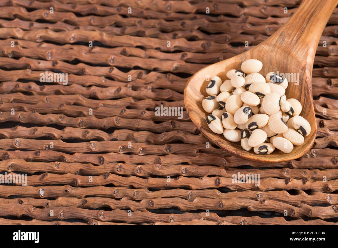 Haricot noir, haricots crus dans la cuillère en bois - Vigna unguiculata Banque D'Images
