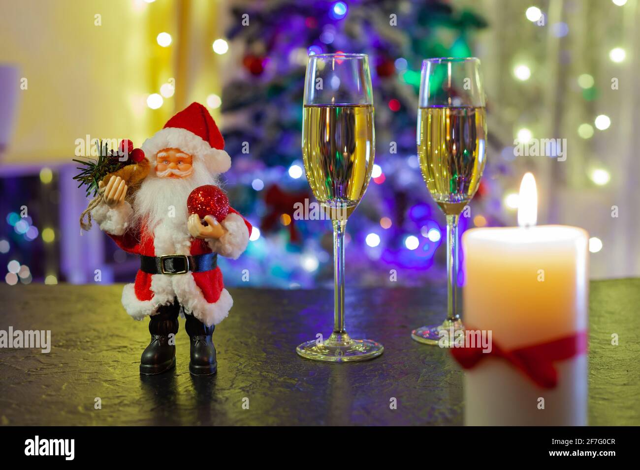 Le Père Noël et deux verres de champagne sur le noir tableau Banque D'Images