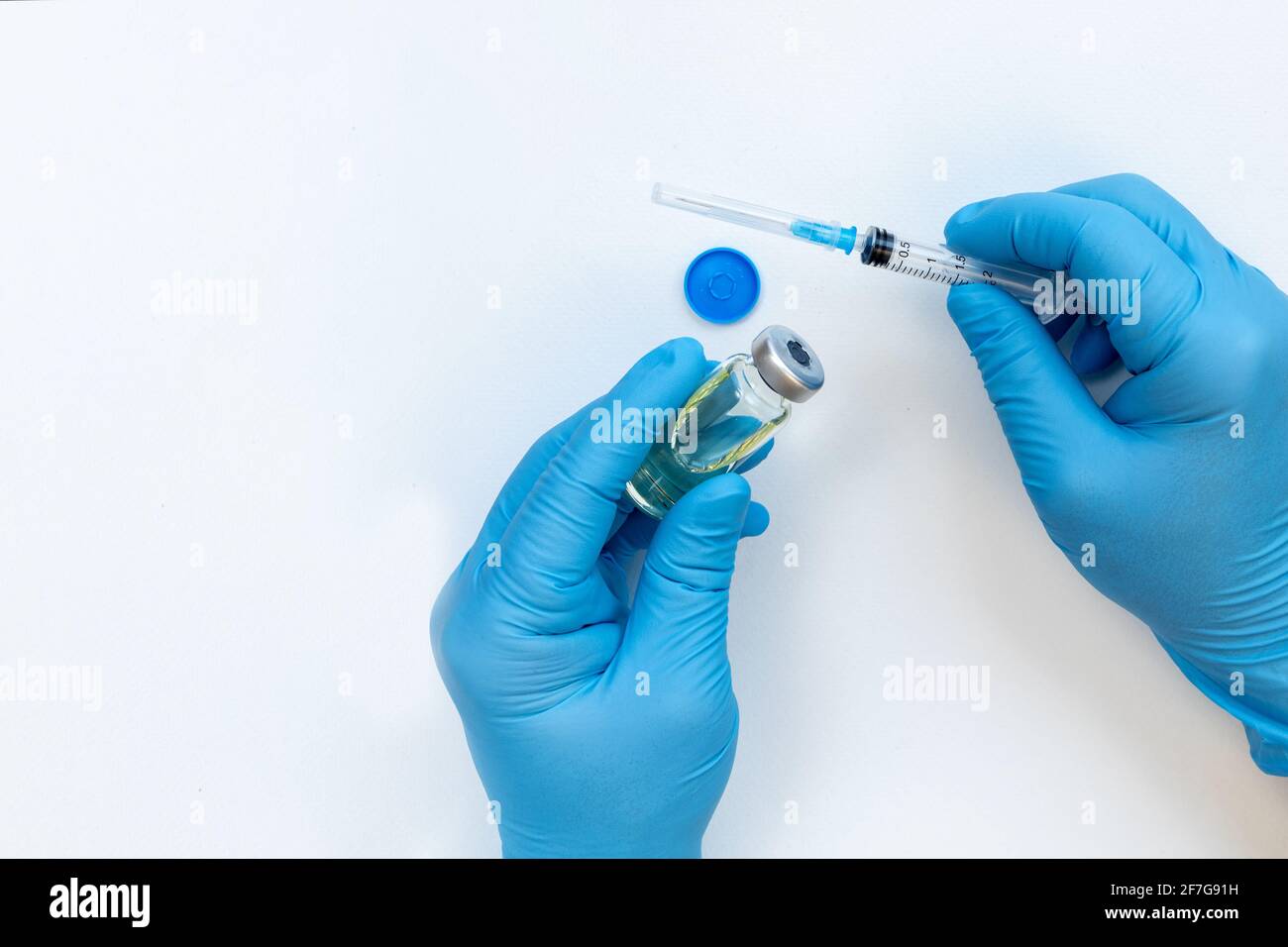 Main du médecin tenant le flacon de médicament et la seringue pour le vaccin au patient sur fond blanc. Immunisation traitement de la grippe concept de vaccination. Banque D'Images