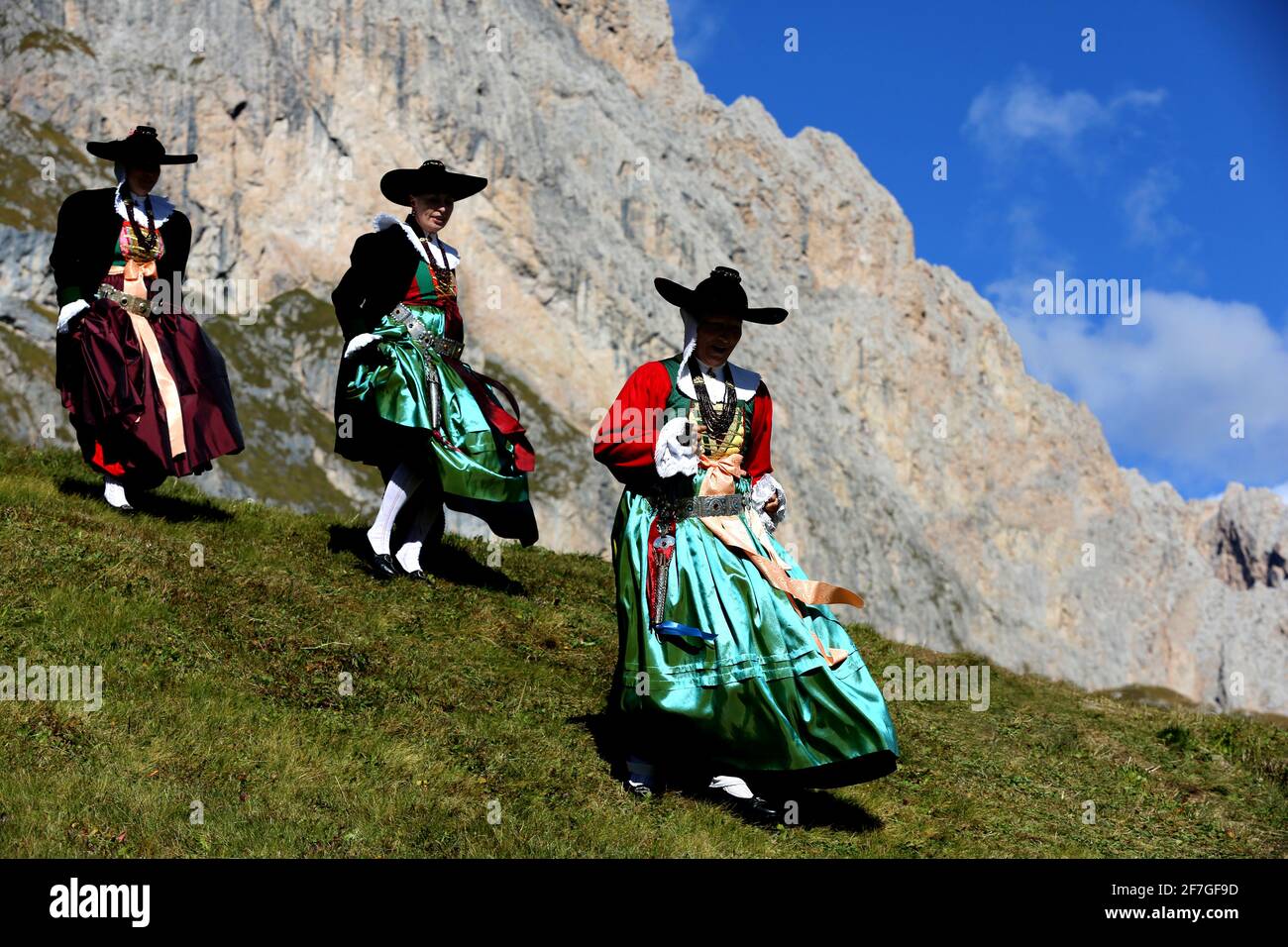 Rei festlich und traditionell geschmückte Frauen in Grödner Tracht auf weg vom Fest auf dem Berg zurück in Tal Dans den Dolomiten dans Südtirol Banque D'Images