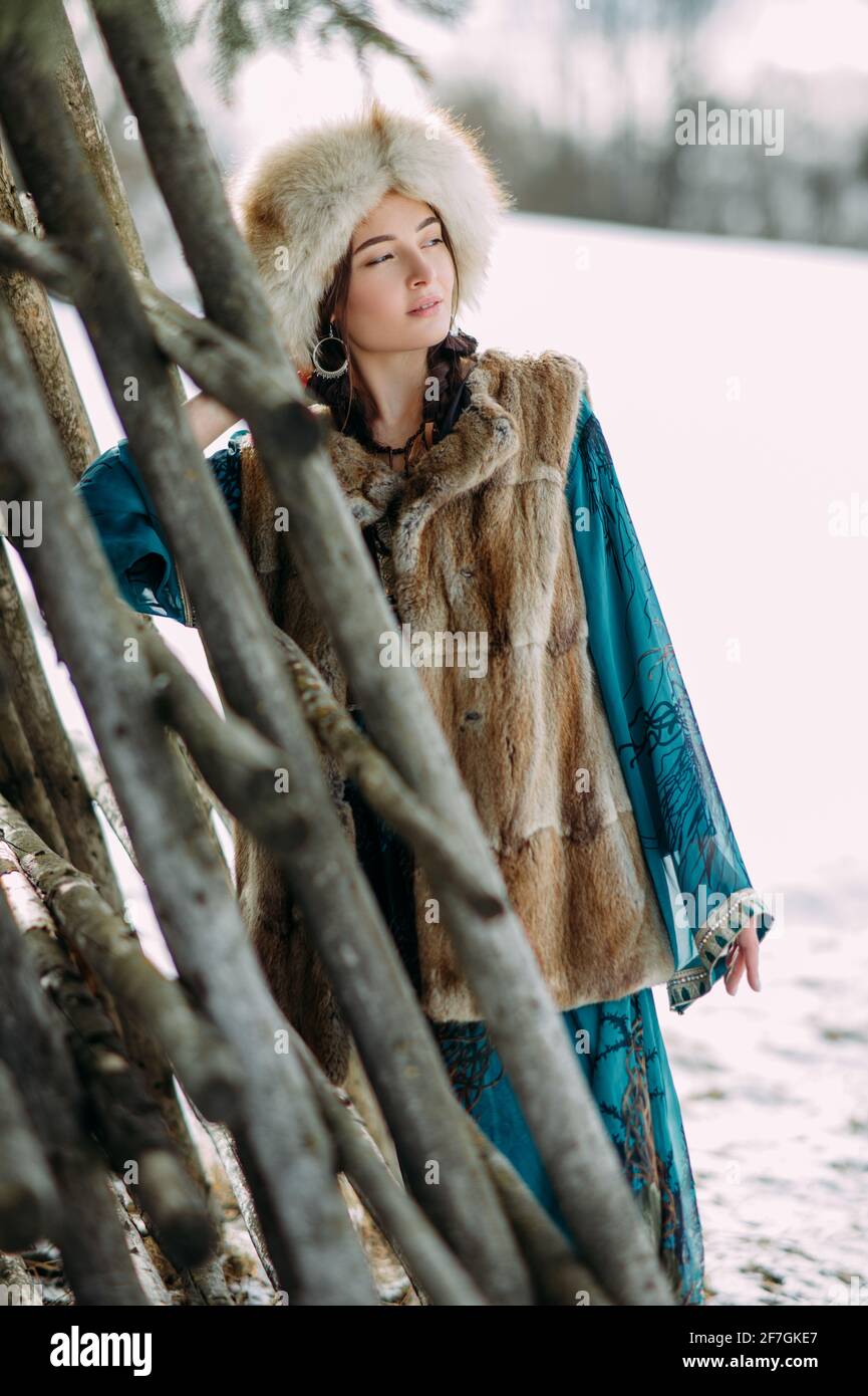 La jeune femme se tient près des adaptations en bois pour sécher le foin  vêtu d'un chapeau de fourrure, d'une veste et d'une robe en Carpates Photo  Stock - Alamy