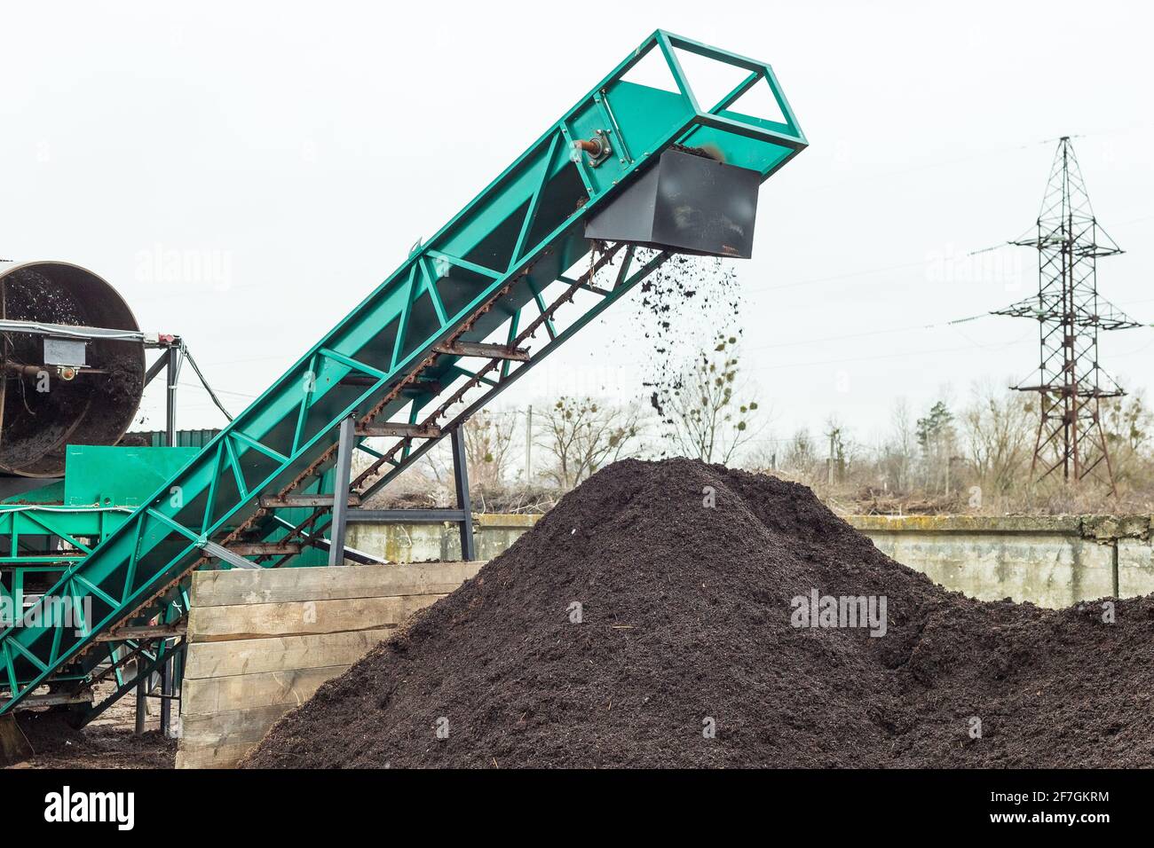 Production de sol à une usine de compost industriel. Tamisage du sol avec une machine pour rendre la terre propre prête à être utilisée Banque D'Images