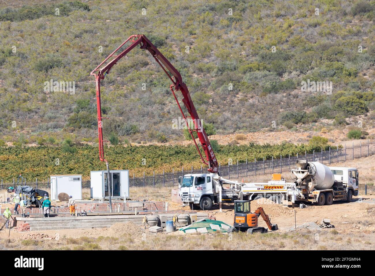 Chantier de construction de maison rurale privée avec grue mobile montée sur un camion versant prêt à mélanger le béton d'un béton batteur pour les sols Banque D'Images
