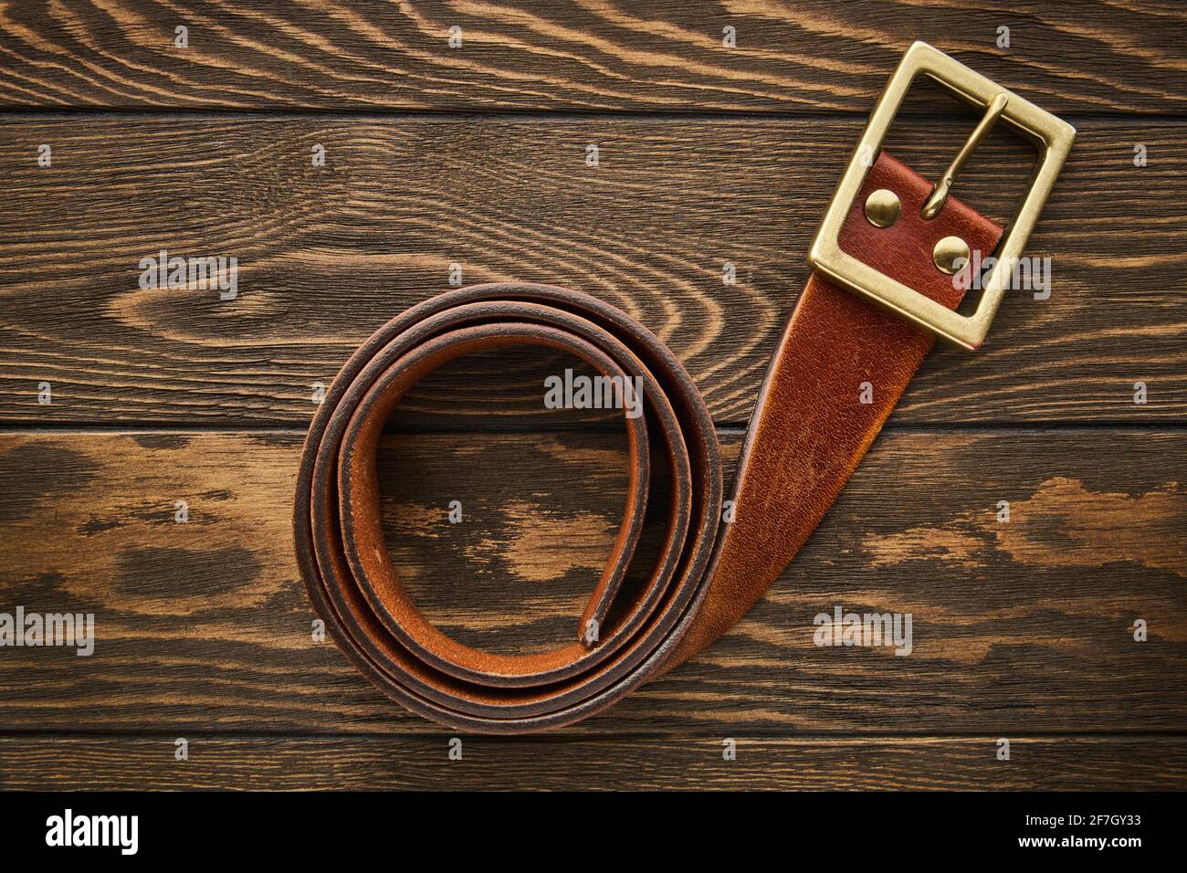 Large ceinture marron pour hommes en cuir véritable avec boucle pour jeans  sur fond en bois, cuir véritable Photo Stock - Alamy