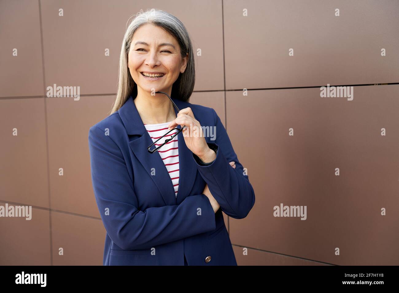 Une dame joyeuse d'âge qui a l'air professionnelle et positive dans un costume élégant Banque D'Images