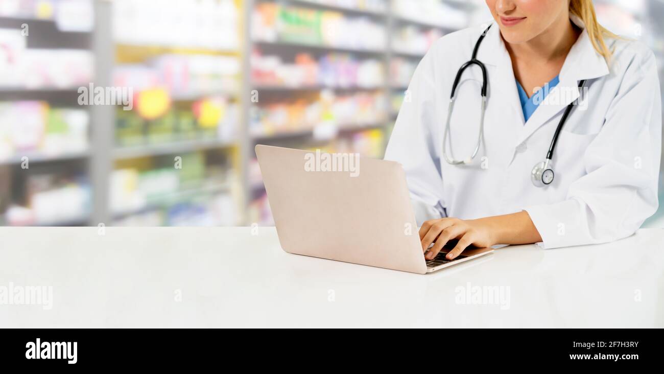Votre pharmacien ou votre médecin à l'aide d'un ordinateur portable à la pharmacie prix. Le personnel médical et pharmaceutique de la santé publique. Banque D'Images