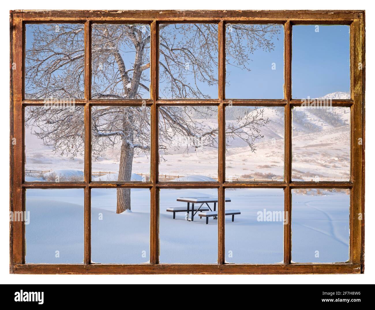 Table de pique-nique recouverte de neige fraîche sur les contreforts des Rocheuses Le matin vu d'une fenêtre de guillotine vintage Banque D'Images