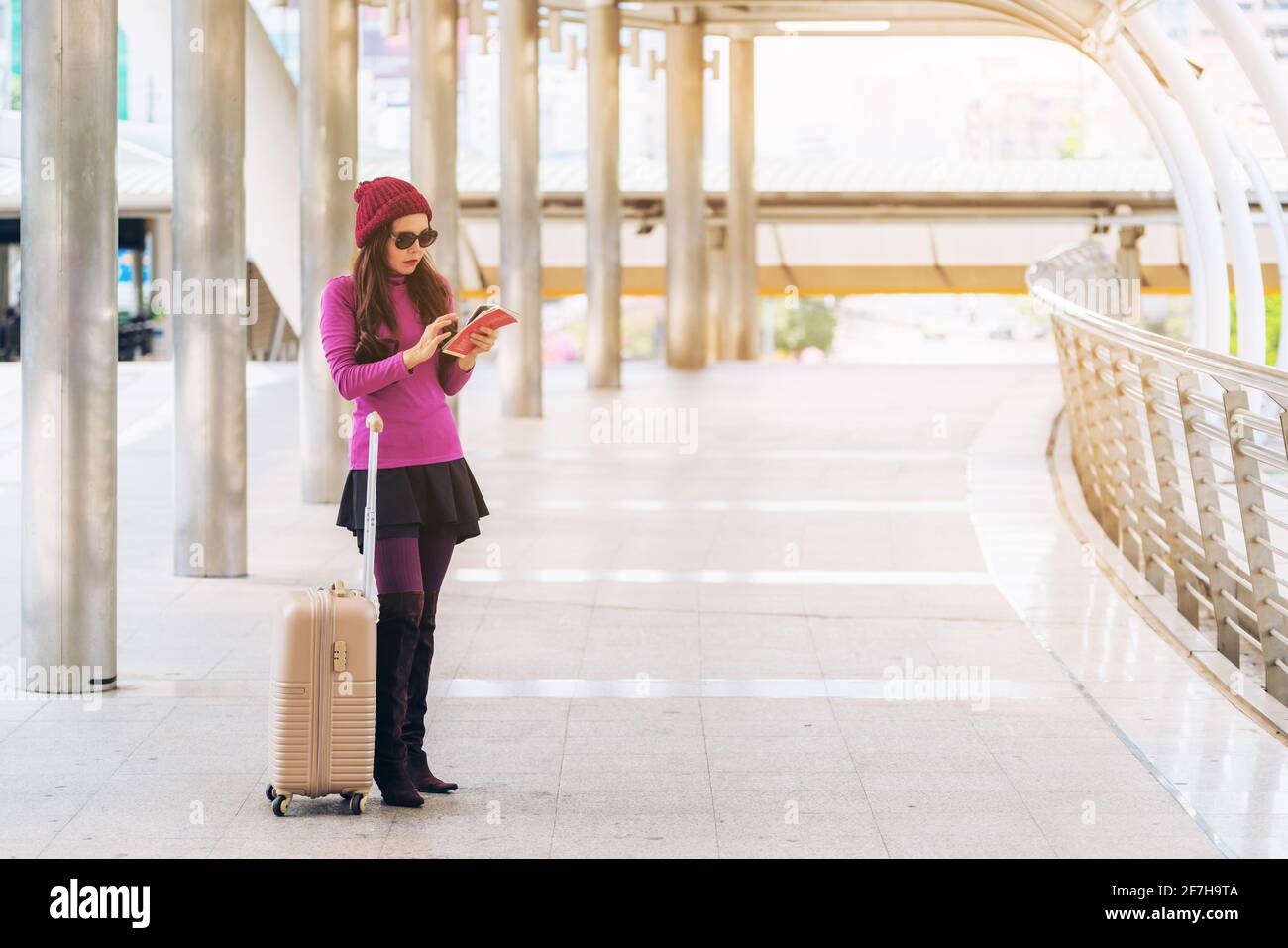 Femme voyageur avec sac de voyage ou bagages marchant dans le passage du terminal de l'aéroport pour voyager à l'étranger. Banque D'Images