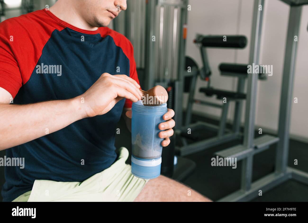 un homme verse des protéines dans un shaker après un entraînement en étant  assis sur un banc dans la salle de gym. nutrition sportive Photo Stock -  Alamy