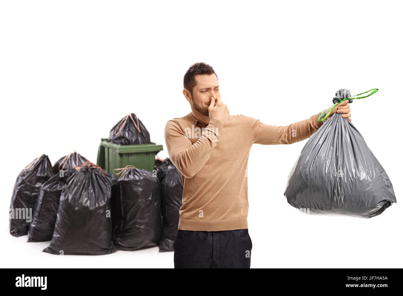Jeune homme tenant un sac poubelle odorant et couvrant son nez près d'une  poubelle isolée sur fond blanc Photo Stock - Alamy