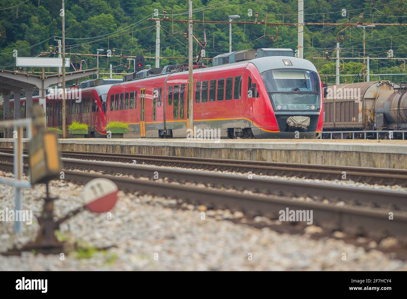 Train moderne de plusieurs unités électriques sur la voie d'une gare de banlieue. Train de banlieue se précipitant vers la ville dans un environnement de banlieue par une journée ensoleillée Banque D'Images