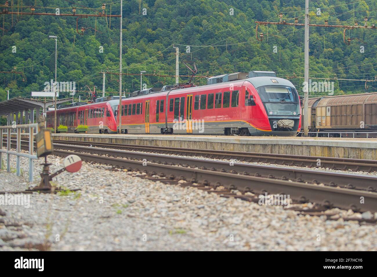 Train moderne de plusieurs unités électriques sur la voie d'une gare de banlieue. Train de banlieue se précipitant vers la ville dans un environnement de banlieue par une journée ensoleillée Banque D'Images