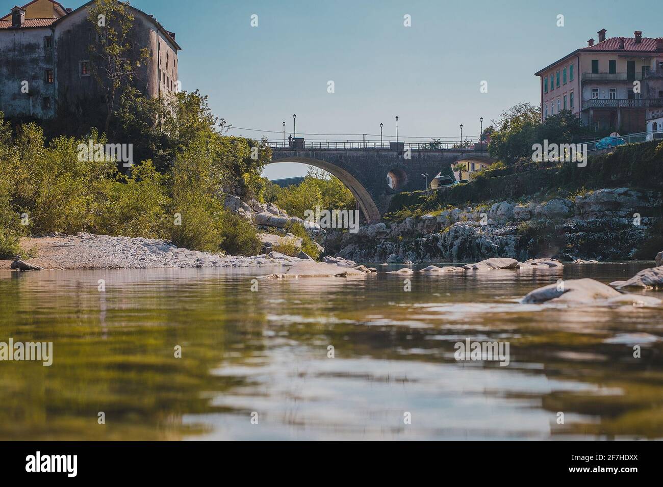 Célèbre pont sur le village de Kanal ob Soci pendant la chaude journée d'été avec la rivière froide Soca coulant sous le pont. Vue sur la grenouille d'un pont à Kanal. Banque D'Images