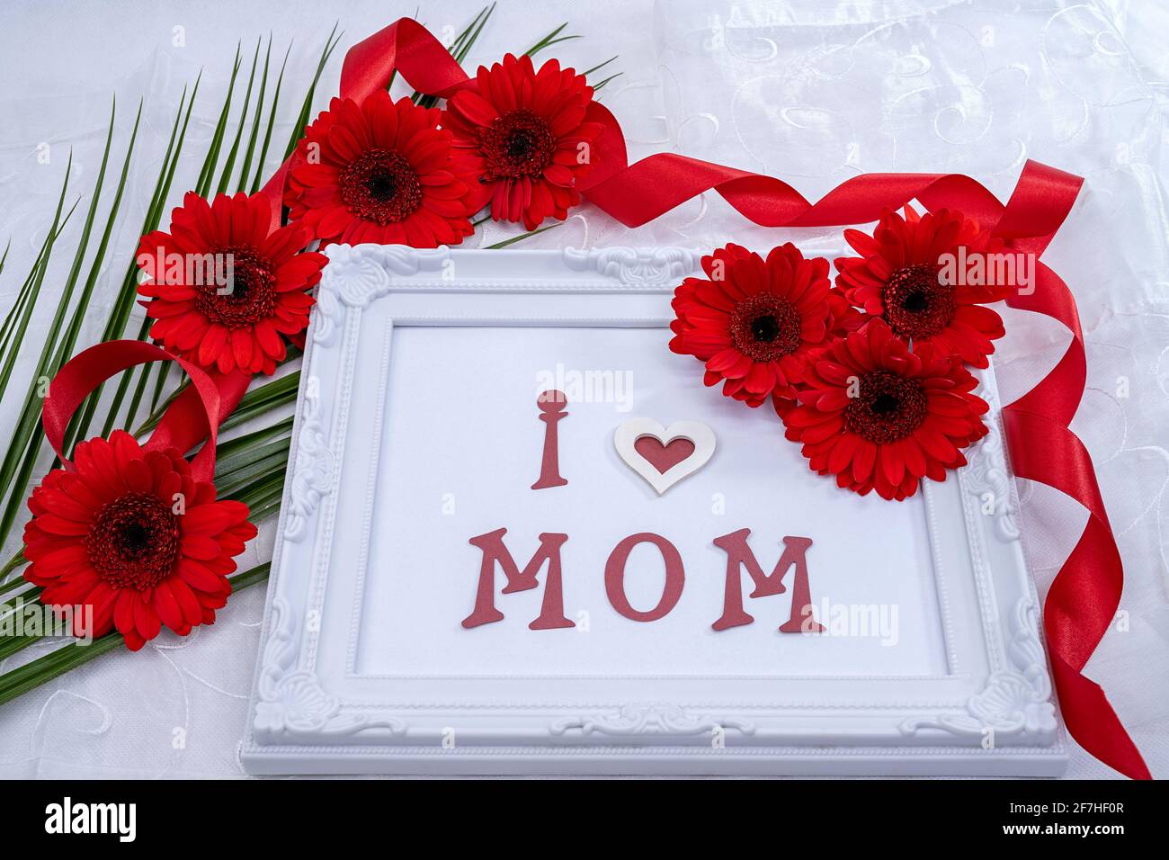 Décoration pour la fête des mères, faite de fleurs gerberas rouges, cadre  photo avec l'écriture I love Maman. Modèle pour la fête des mères Photo  Stock - Alamy