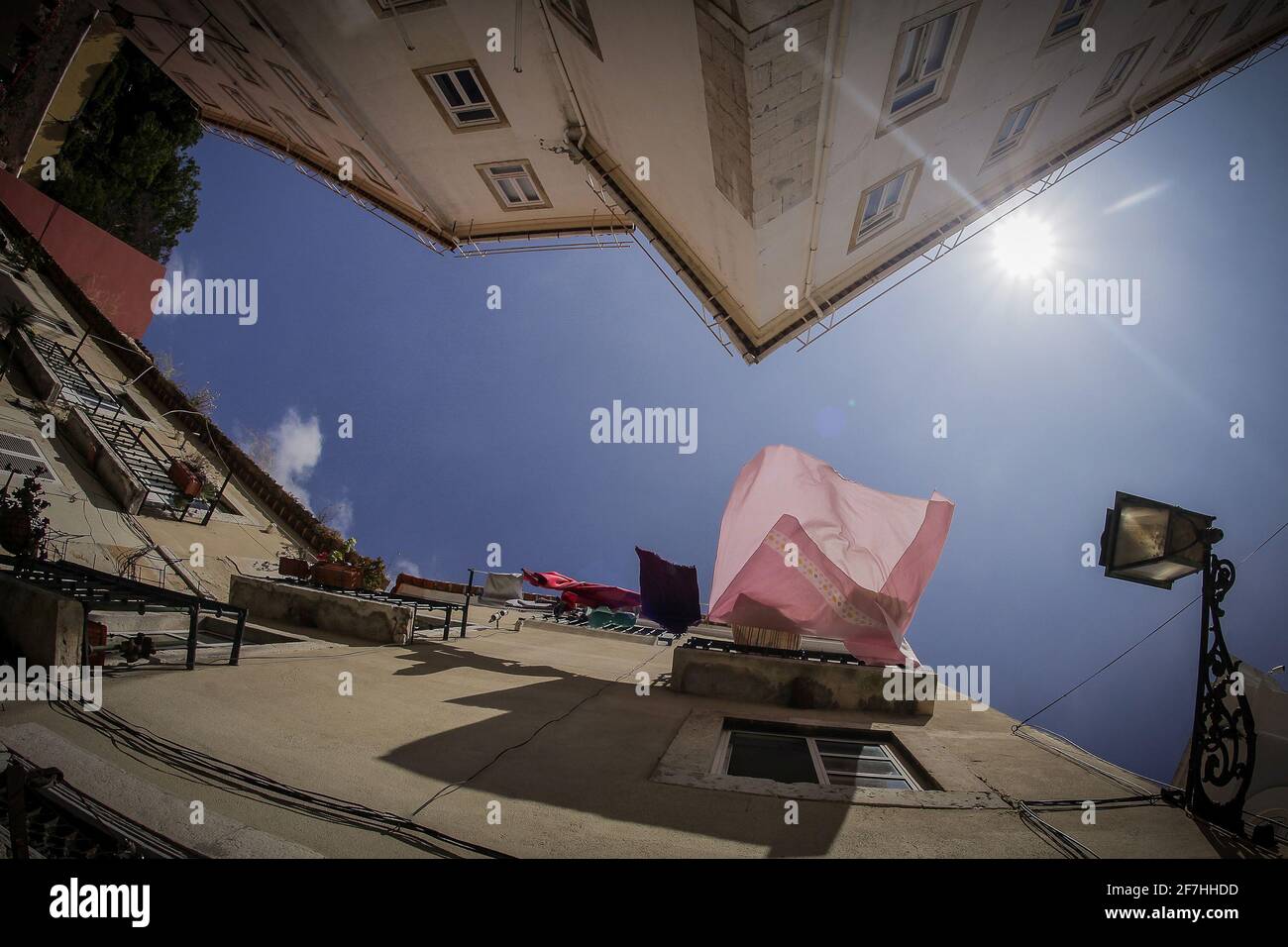 Chercher à voir les draps et les serviettes qui sèchent au soleil sur un balcon d'un bâtiment à Lisbonne, Portugal. Banque D'Images