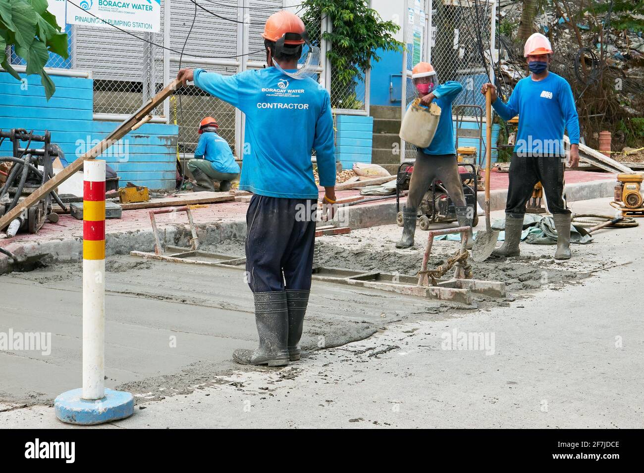 Les travailleurs de la construction routière de Boracay Water en action, cimentant la route principale sur l'île Boracay, province d'Aklan, Philippines pendant la pandémie. Banque D'Images