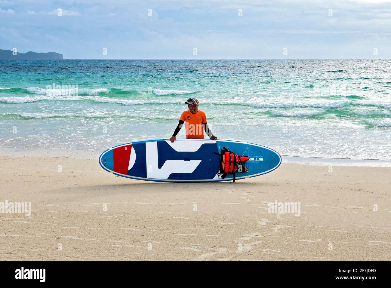 Jeune instructeur tenant un bateau à aubes à la plage blanche propre et vide sur l'île Boracay, province d'Aklan, Philippines, Asie, aux heures d'écluse Banque D'Images