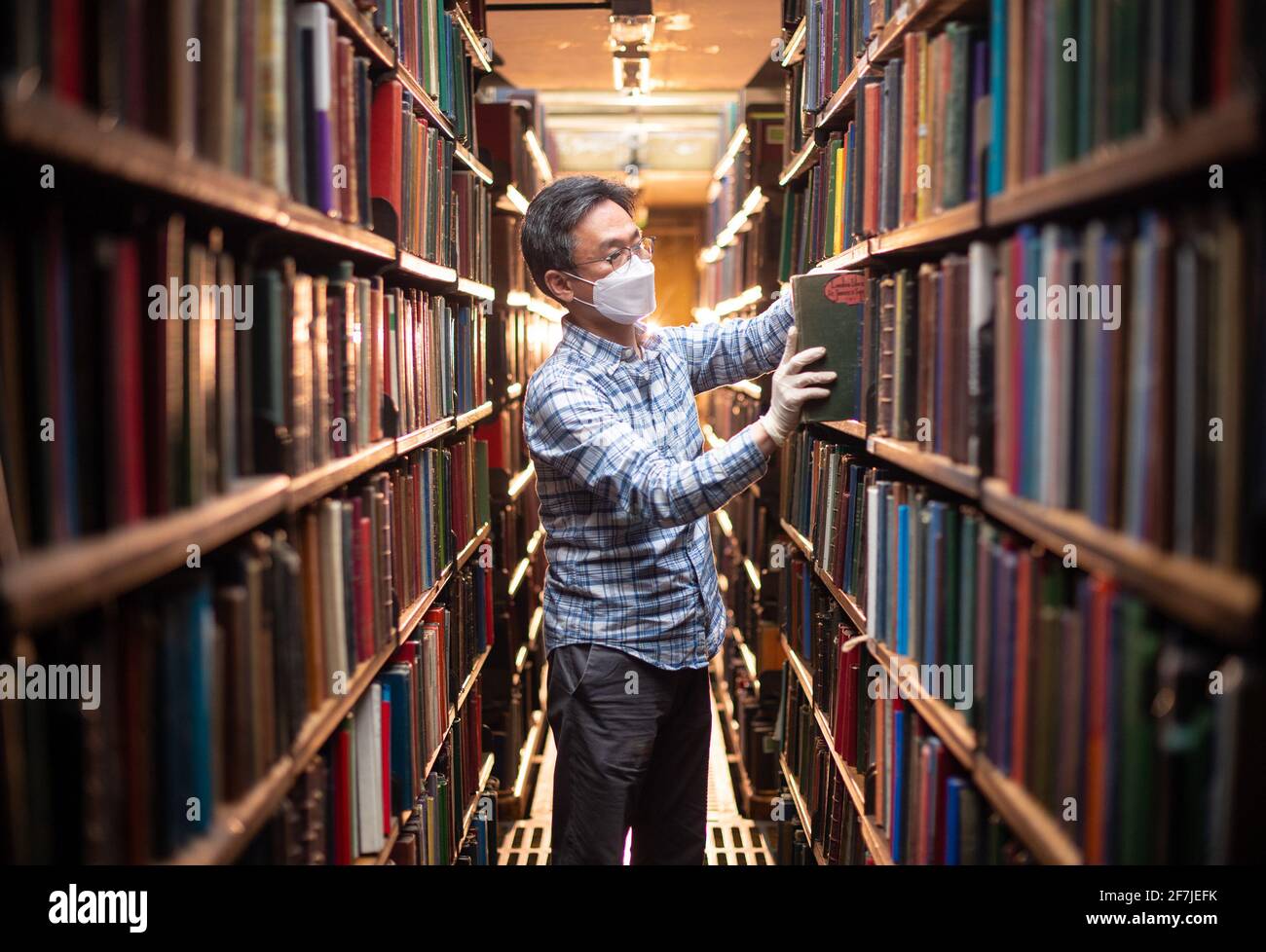 Chung Hoon organise des livres dans les piles de livres à l'arrière de la London Library, à St James Square, Londres, en prévision de sa réouverture prévue aux membres le 12 avril, alors que le gouvernement atténue les restrictions actuelles concernant les coronavirus. Date de la photo: Mercredi 7 avril 2021. La London Library a été créée en 1841 et sa collection compte plus de 1,000,000 titres, couvrant plus de 2,000 sujets dans 55 langues différentes. Les livres vont de 1500 à 2015, complétés par des copies reliées de plus de 2,000 périodiques datant de 1699 à aujourd'hui. Banque D'Images