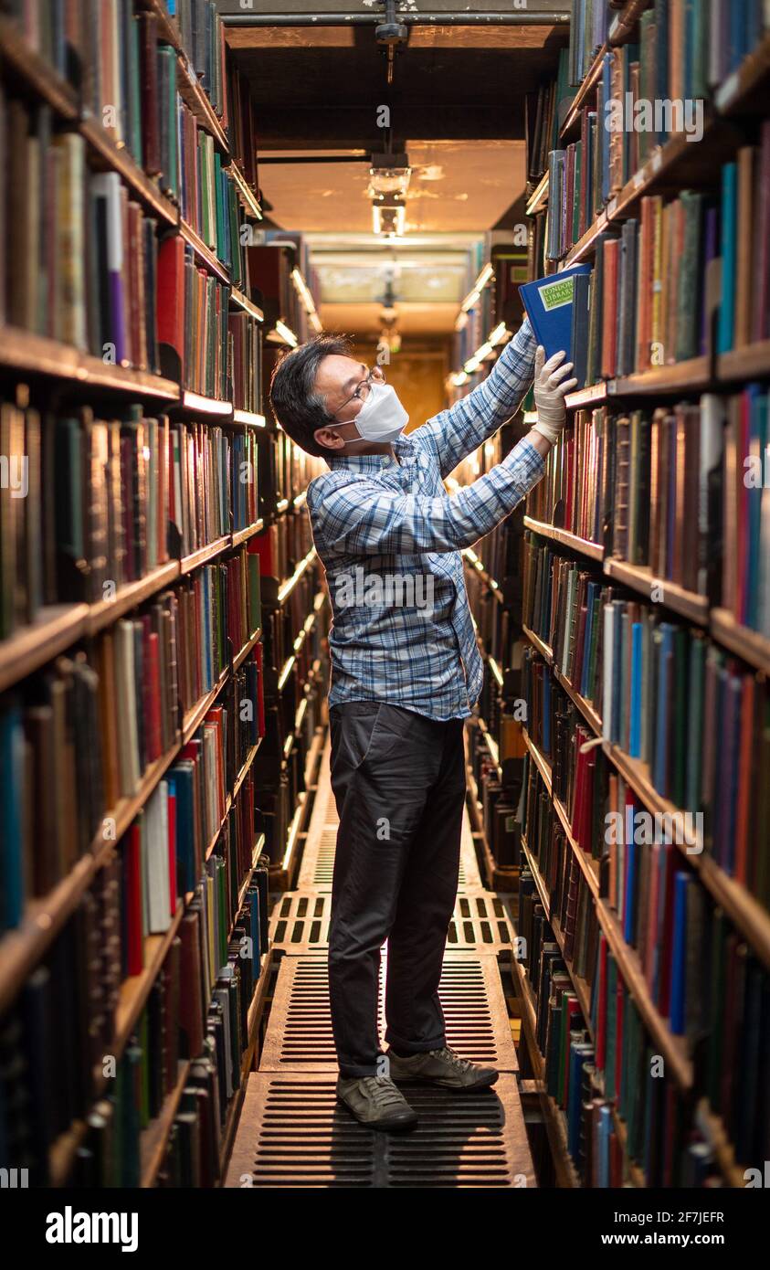 Chung Hoon organise des livres dans les piles de livres à l'arrière de la London Library, à St James Square, Londres, en prévision de sa réouverture prévue aux membres le 12 avril, alors que le gouvernement atténue les restrictions actuelles concernant les coronavirus. Date de la photo: Mercredi 7 avril 2021. La London Library a été créée en 1841 et sa collection compte plus de 1,000,000 titres, couvrant plus de 2,000 sujets dans 55 langues différentes. Les livres vont de 1500 à 2015, complétés par des copies reliées de plus de 2,000 périodiques datant de 1699 à aujourd'hui. Banque D'Images