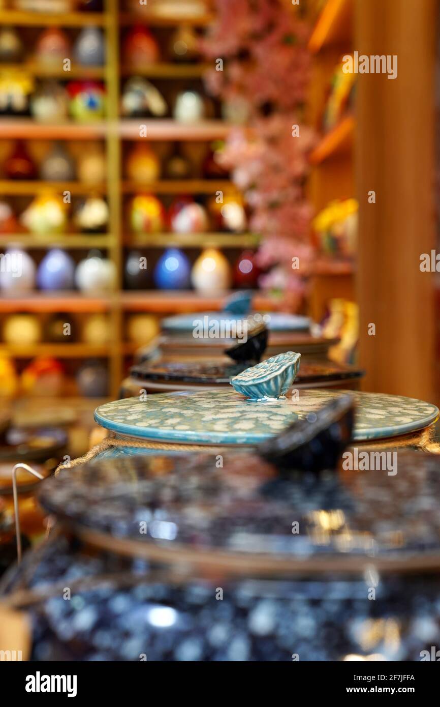 Réservoirs à liqueur chinoise colorés avec dessus de lotus et étagère de bouteilles de liqueur derrière à Suzhou. Banque D'Images