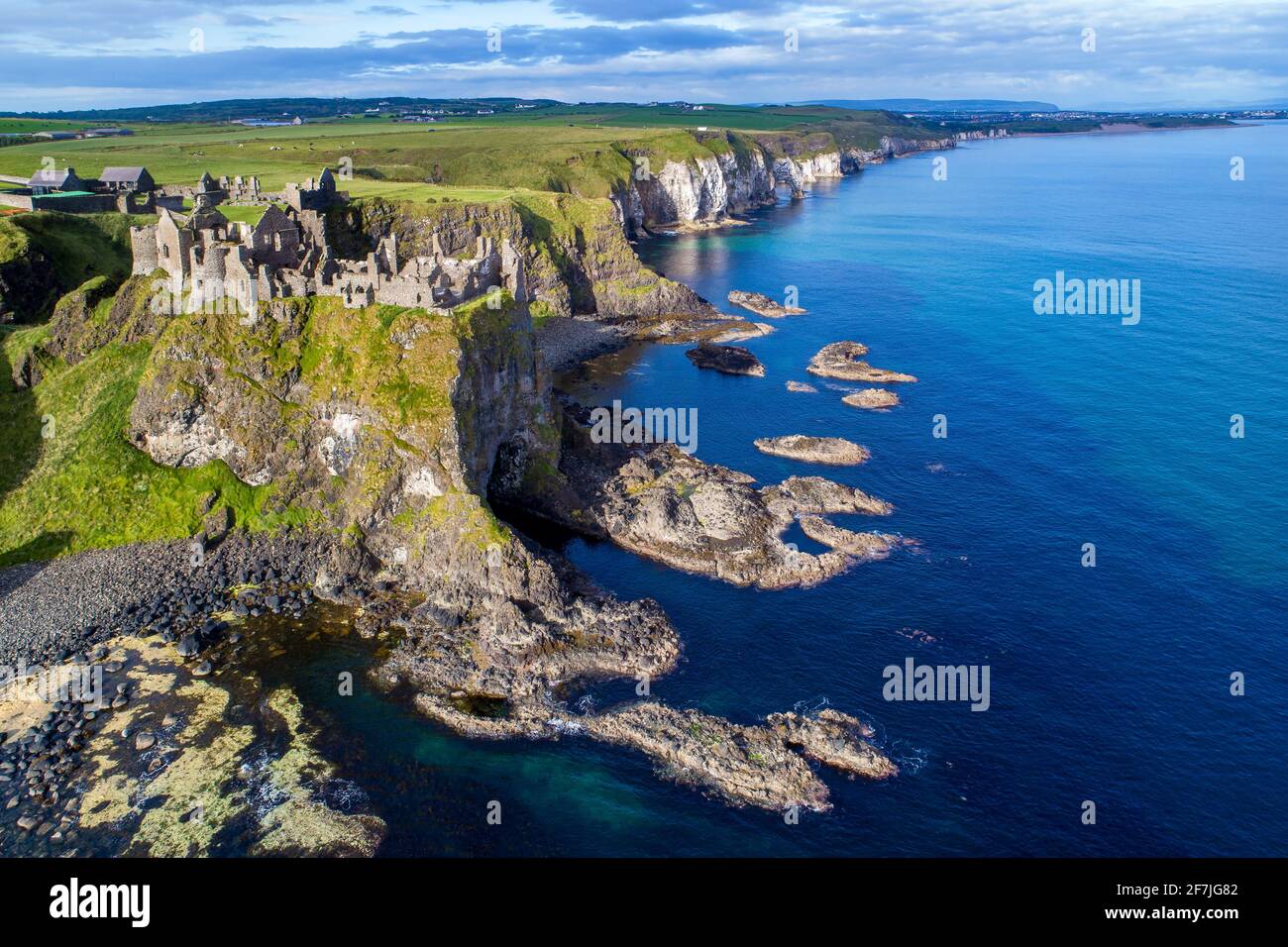 Ruines du château de Dunluce médiévale, les falaises, les baies et péninsules. Côte nord du comté d'Antrim, Irlande du Nord, Royaume-Uni. Vue aérienne. Banque D'Images