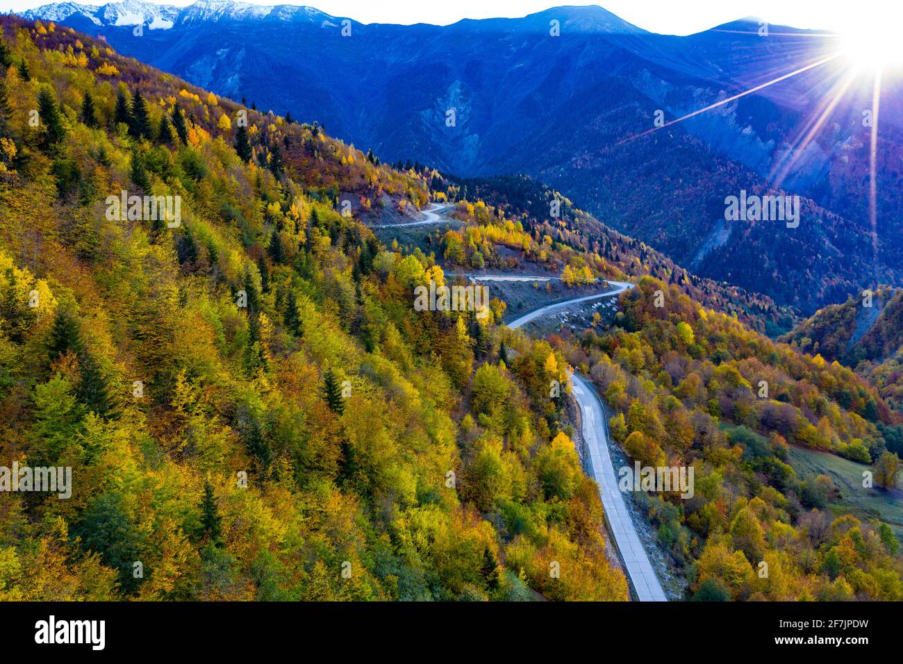 Route sinueuse dans les montagnes, vue sur la forêt d'automne depuis un drone Banque D'Images