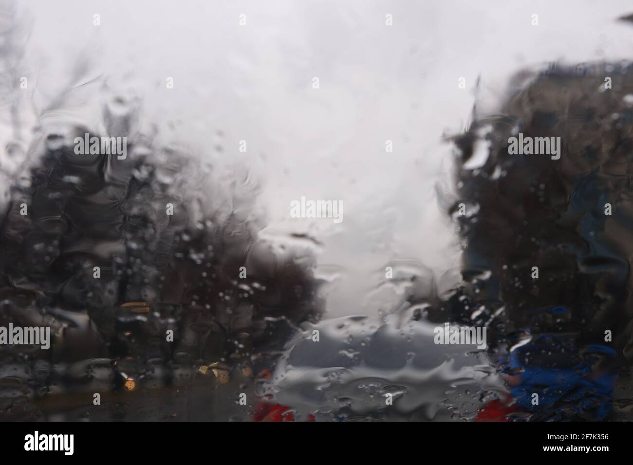 Gouttes d'eau sur la fenêtre lors d'un jour de pluie, circulation sur routes mouillées Banque D'Images