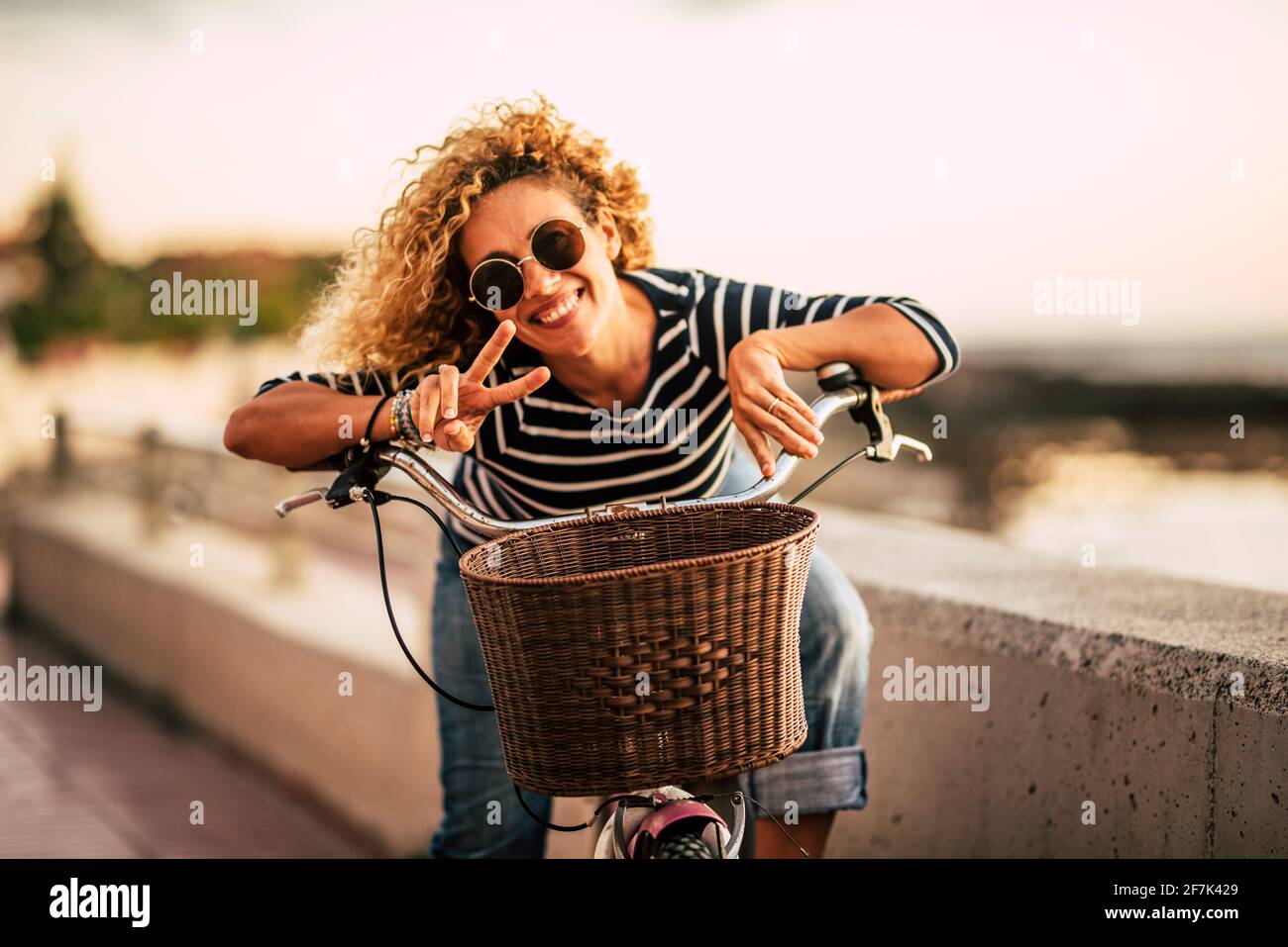 Portrait d'une belle femme adulte d'âge moyen souriant et ayant plaisir de regarder la caméra - femmes actives avec vélo et mode de vie sain outdo Banque D'Images