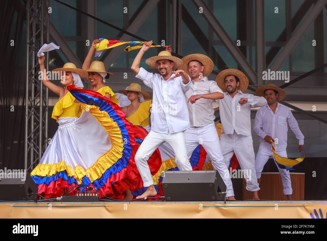 Danseurs colombiens sur scène. Les femmes portent les couleurs nationales colombiennes et les hommes sont habillés comme des fermiers avec des sombreros Banque D'Images