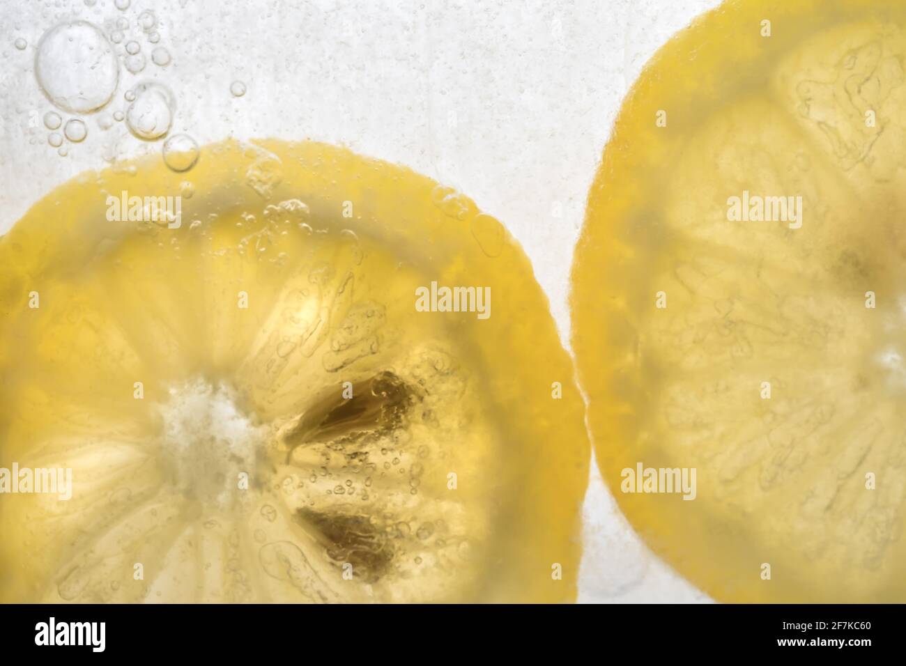 Tranche de citron dans un bloc gelé de glace d'eau. Translucide et lumière de l'arrière. Arrière-plan blanc. Espace pour le texte. Banque D'Images