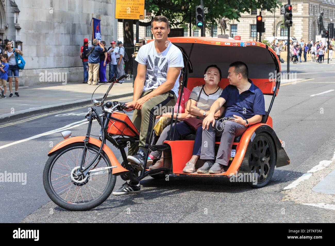 Touristes asiatiques sur un vélo-pousse (vélo-taxi ou pédicab) à Westminster, Londres, Angleterre Banque D'Images