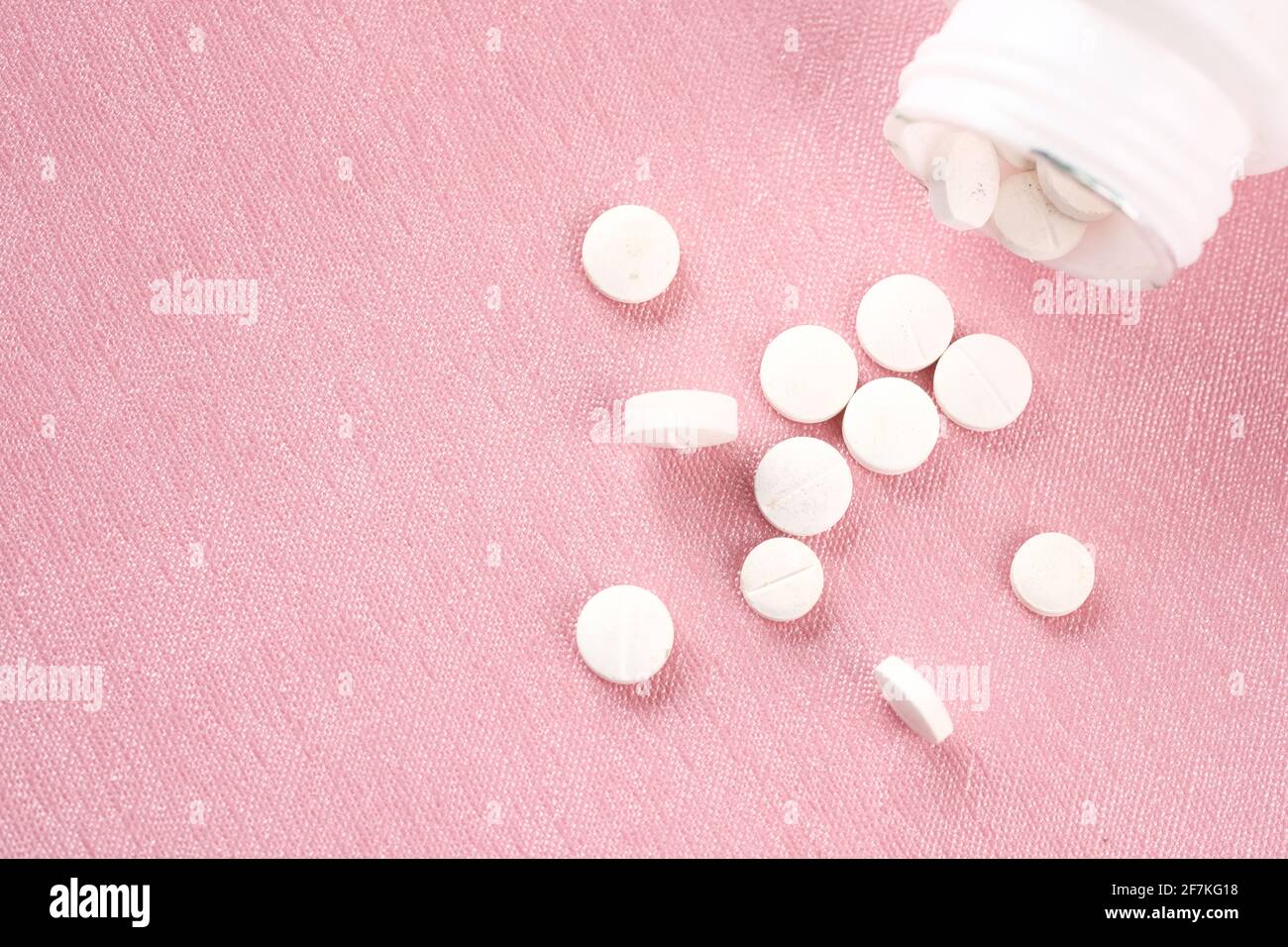 gros plan de pilules médicales de couleur blanche sur fond rose Banque D'Images