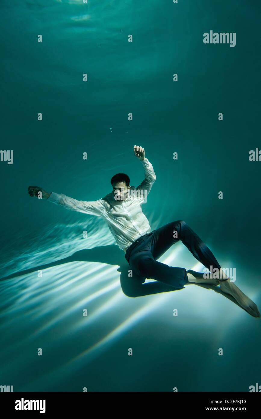 Homme arabe en tenue habillee assis sur le fond de la natation piscine Photo Stock Alamy