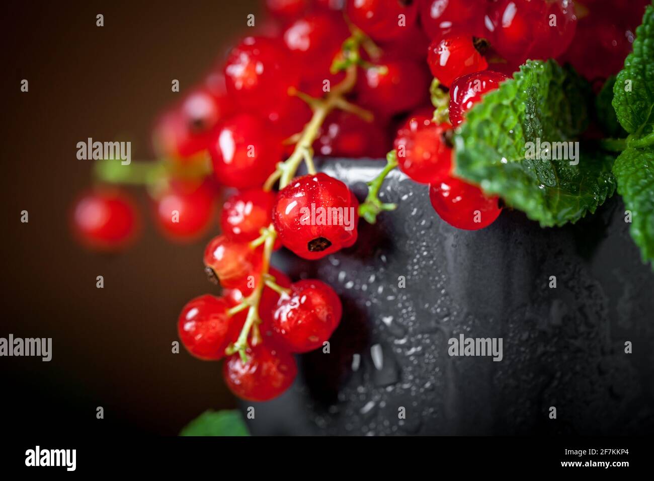 Raisins de Corinthe frais rouges dans une tasse sur une table en bois rustique foncé. Arrière-plan avec espace pour la copie. Mise au point sélective. Horizontale. Banque D'Images