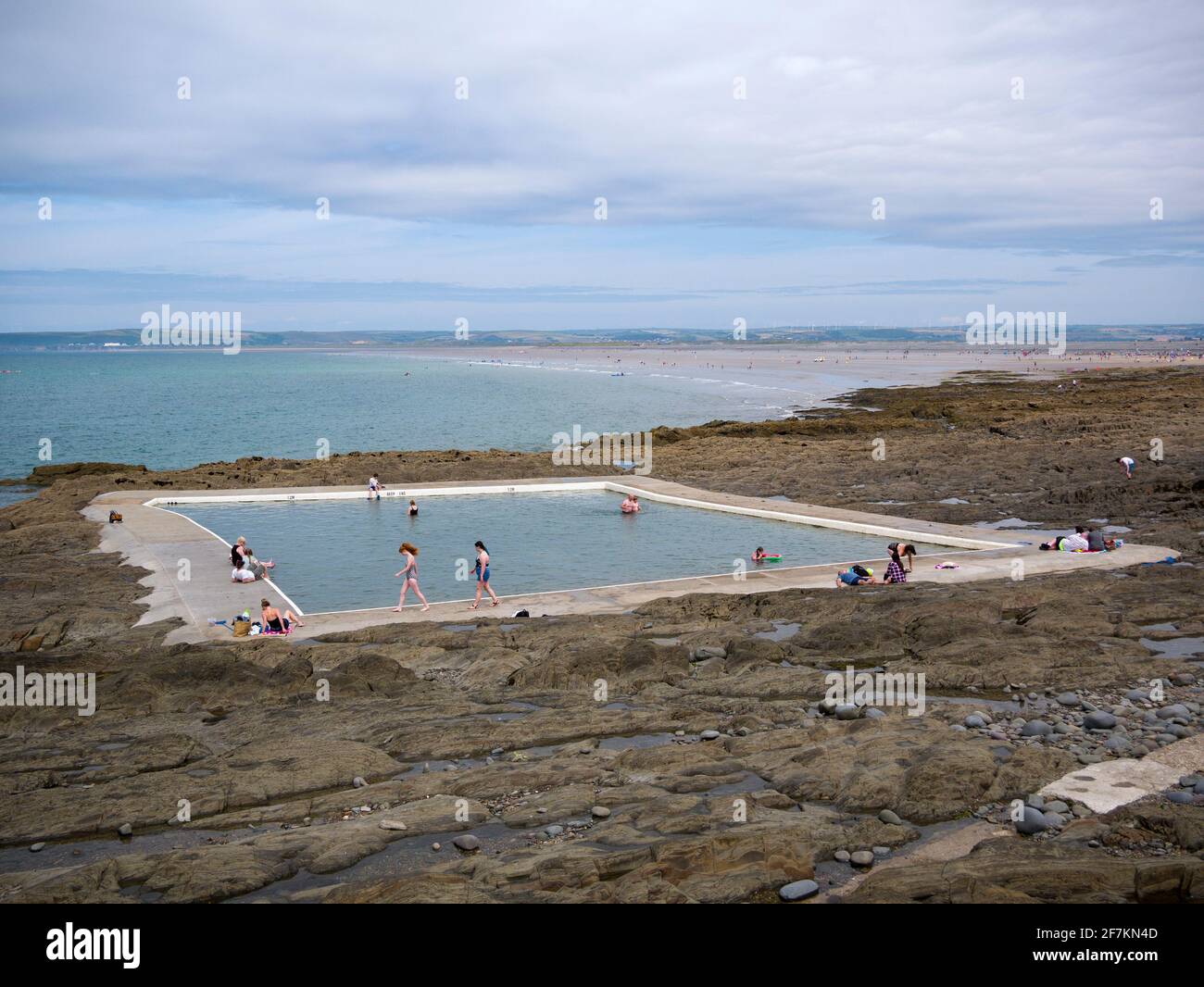 Les gens qui apprécient la piscine à marée extérieure de Rock Pool au village de bord de mer de Westward Ho!, North Devon, Angleterre. Banque D'Images