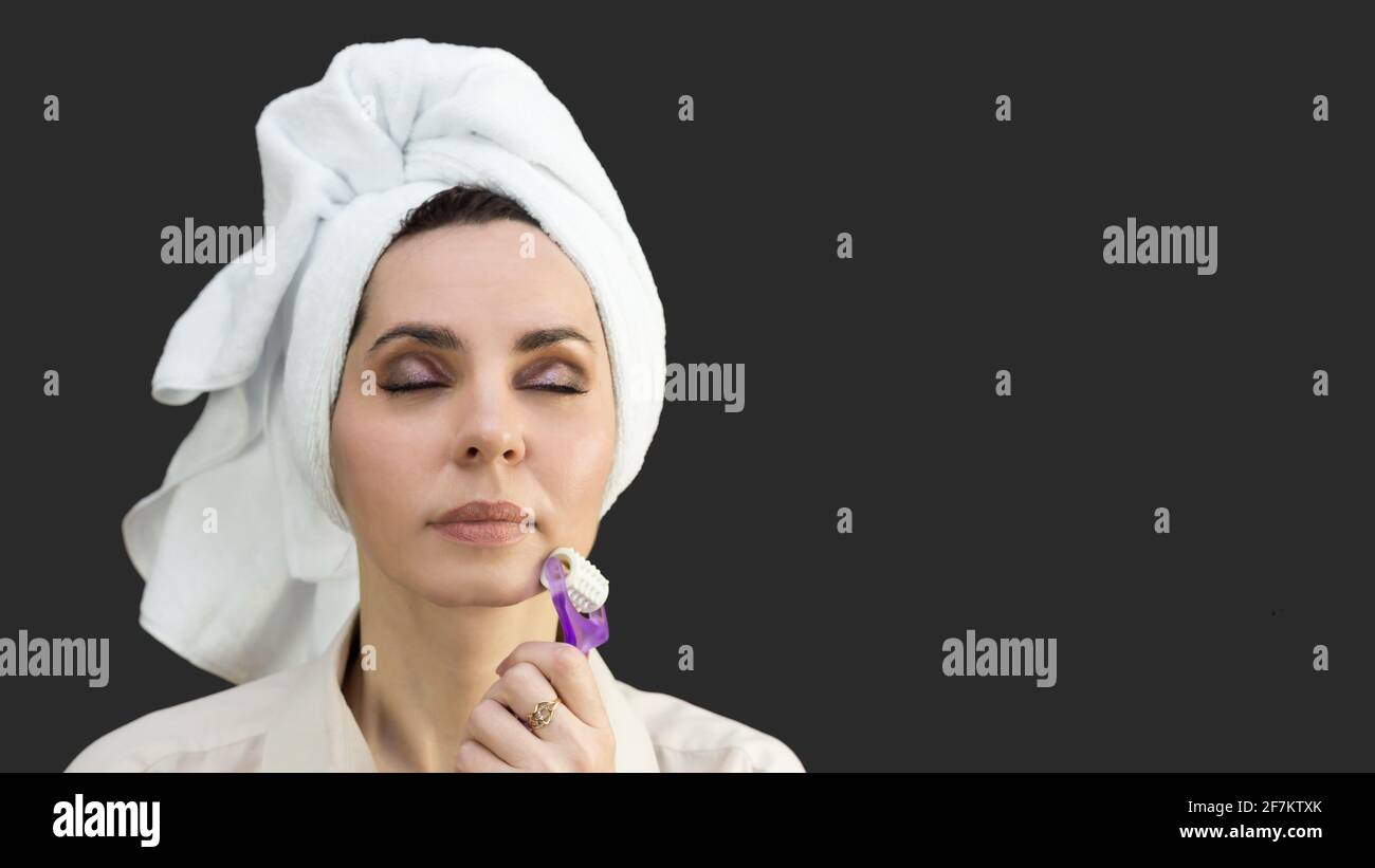 La femme lisse la peau sur le visage des rides avec un espace de copie du masseur Banque D'Images