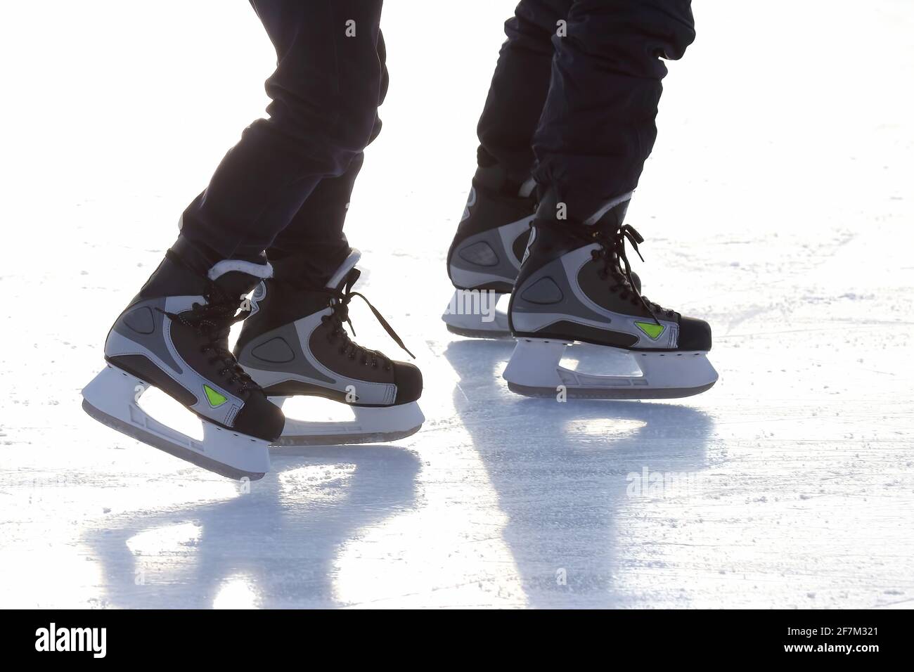 les pieds de différentes personnes patinant sur la patinoire Banque D'Images