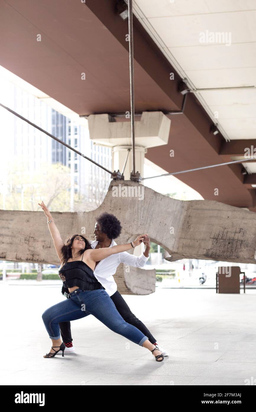 Couple multiethnique de danseurs urbains s'amusant dans le centre-ville. Espace pour le texte. Banque D'Images