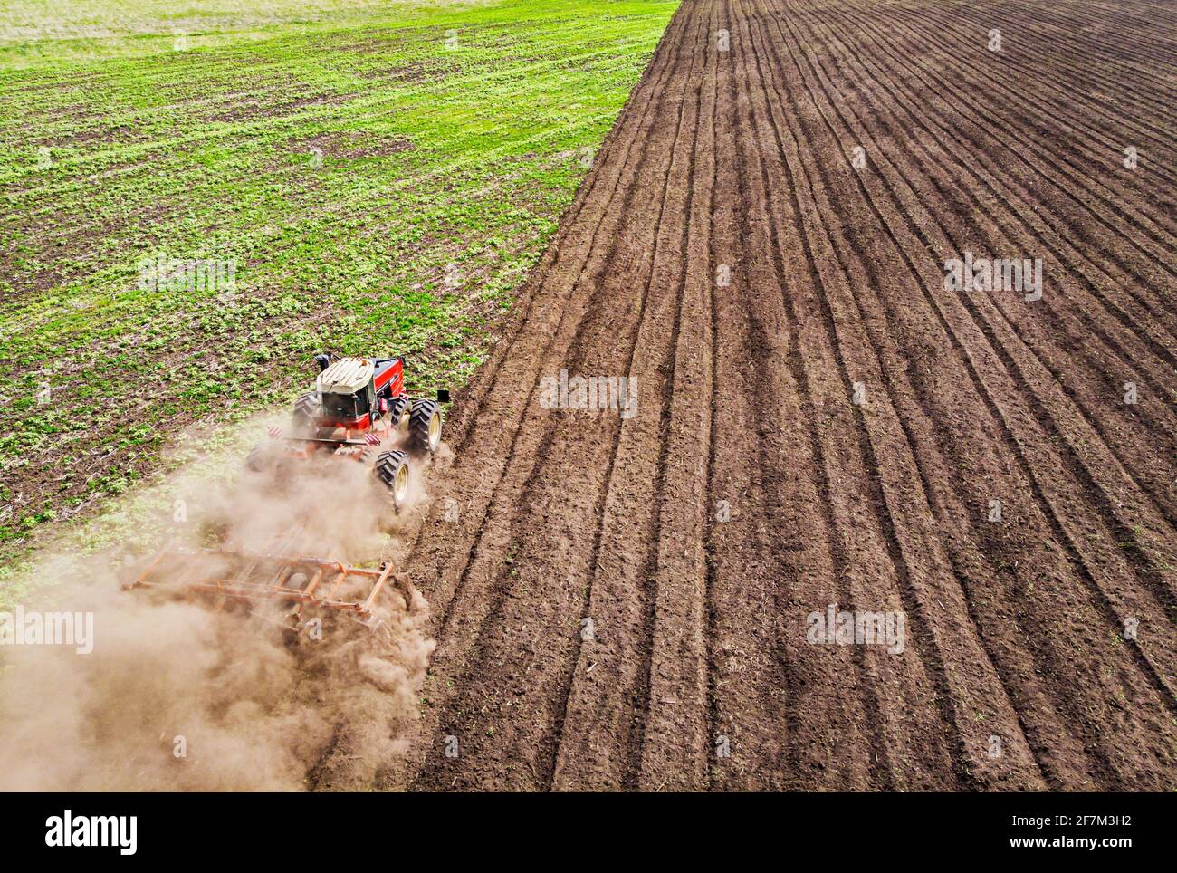 Une grande machine agricole cultive la terre. La vue du dessus. Labourage de terres pour la plantation de cultures. Photos de la vue de l'oiseau avec un quadc Banque D'Images