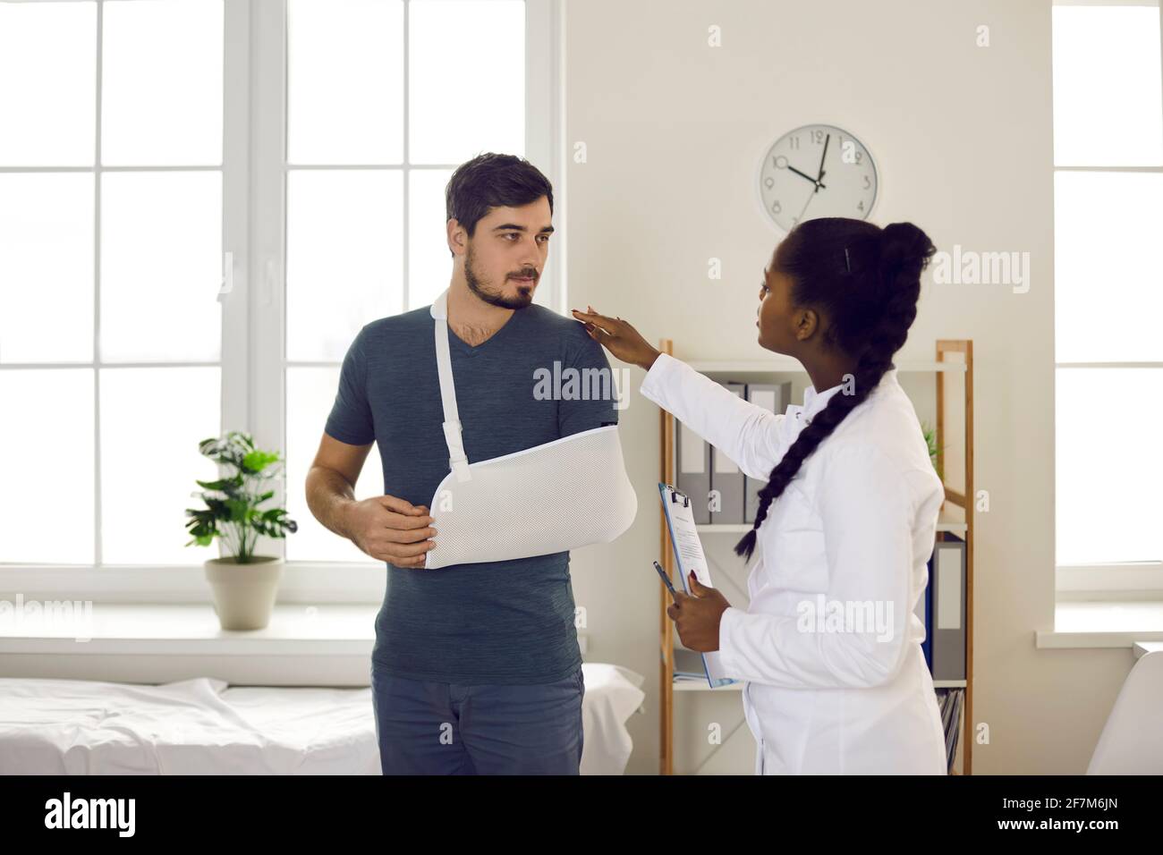 Un médecin afro-américain effectue un examen médical sur un patient à la main blessures Banque D'Images