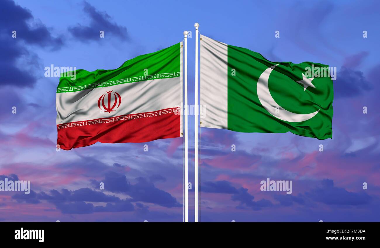 Le Pakistan et l'Iran drapeaux dans le vent contre ciel bleu nuageux blanc ensemble. Concept de diplomatie, de relations internationales. Banque D'Images