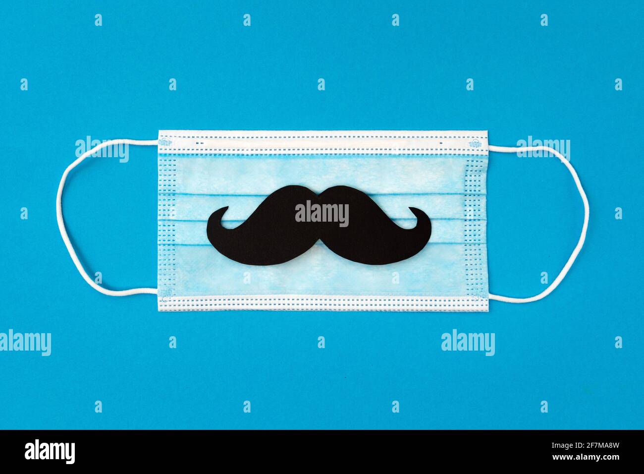 carte de voeux pour la fête des pères et masque protecteur avec moustache sur fond bleu, concept dads jour en quarantaine Banque D'Images
