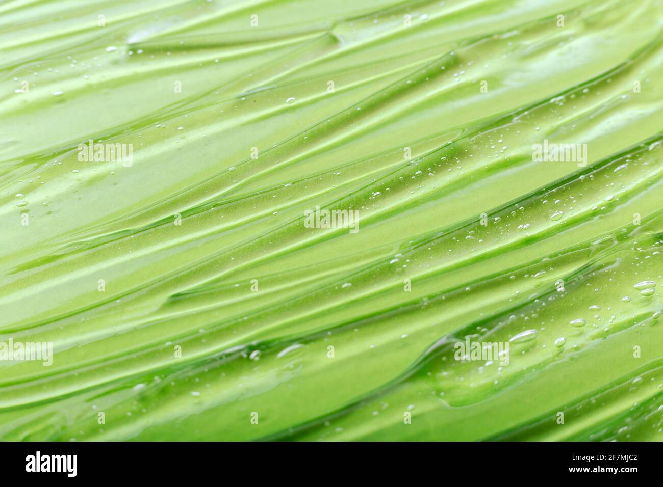 Texture de gel d'aloe vera. Vert liquide transparent gel sérum comme fond ou surface de gel. Produit cosmétique pour les soins de la peau ou gel liquide médical Banque D'Images