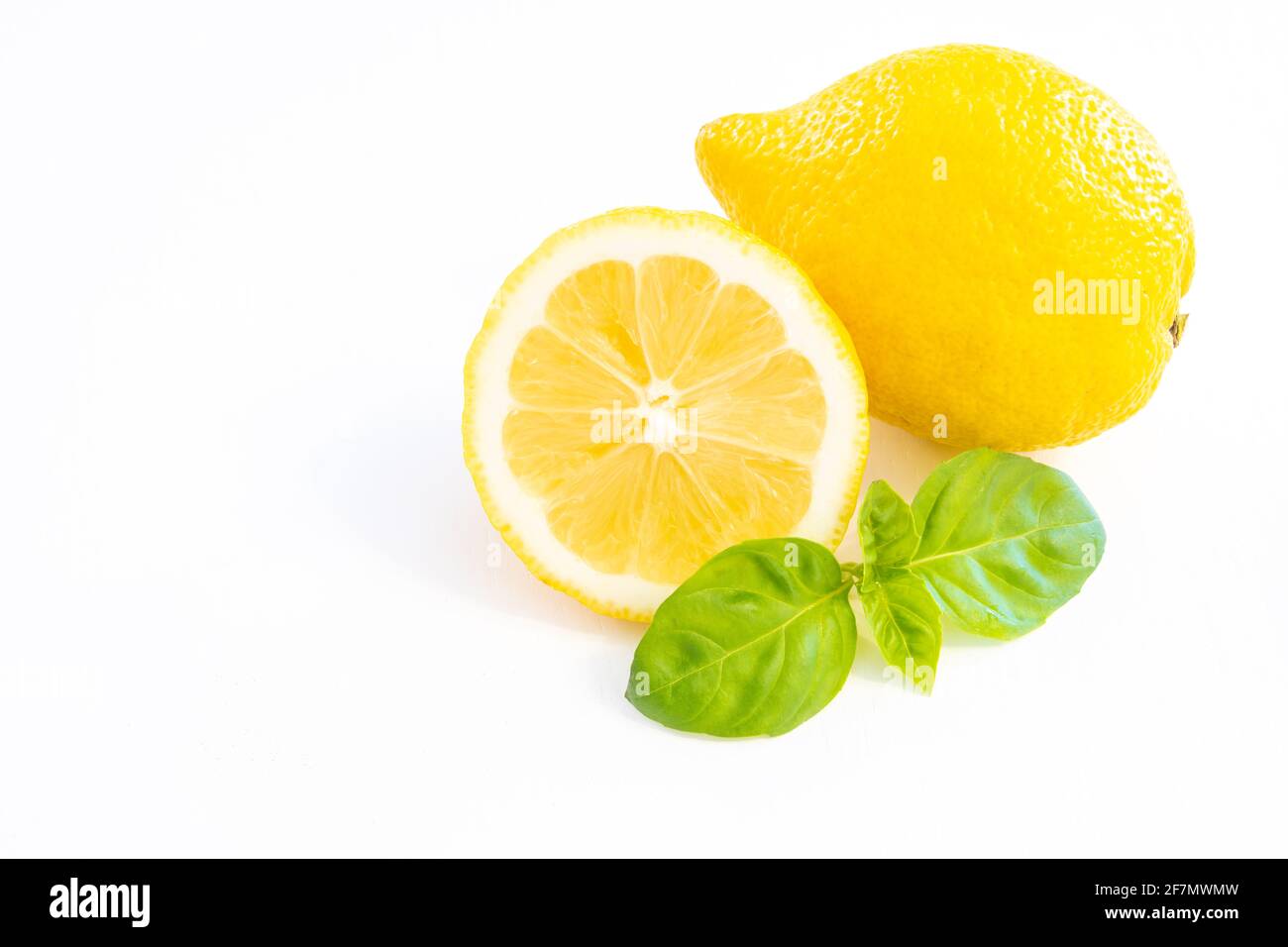 Citron jaune entier avec un demi citron isolé sur blanc arrière-plan avec feuille et espace de copie Banque D'Images