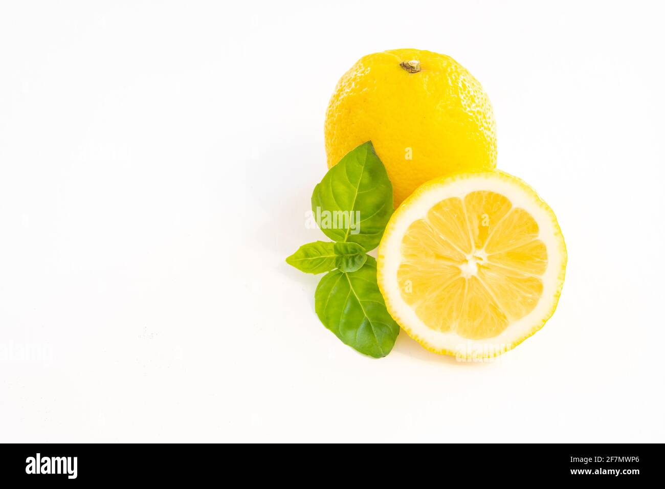 Citron jaune entier avec un demi citron isolé sur blanc arrière-plan avec feuille et espace de copie Banque D'Images