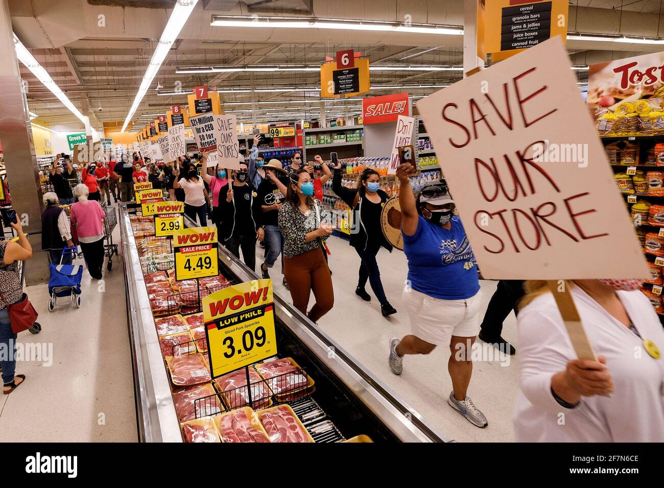 Los Angeles, Californie, États-Unis. 8 avril 2021. Les employés des épiceries de première ligne et leurs partisans qui détiennent des affiches défilent à l'intérieur d'une épicerie de moins de 4 aliments lors d'une démonstration pour appeler la société Kroger à payer les frais temporaires de leurs employés et appeler la société de supermarchés nationale à ne pas fermer ses magasins en représailles aux ordonnances locales qui l'exigent L'augmentation temporaire de la rémunération pendant l'éclosion de la coronavirus (COVID-19). Crédit: Ringo Chiu/ZUMA Wire/Alay Live News Banque D'Images