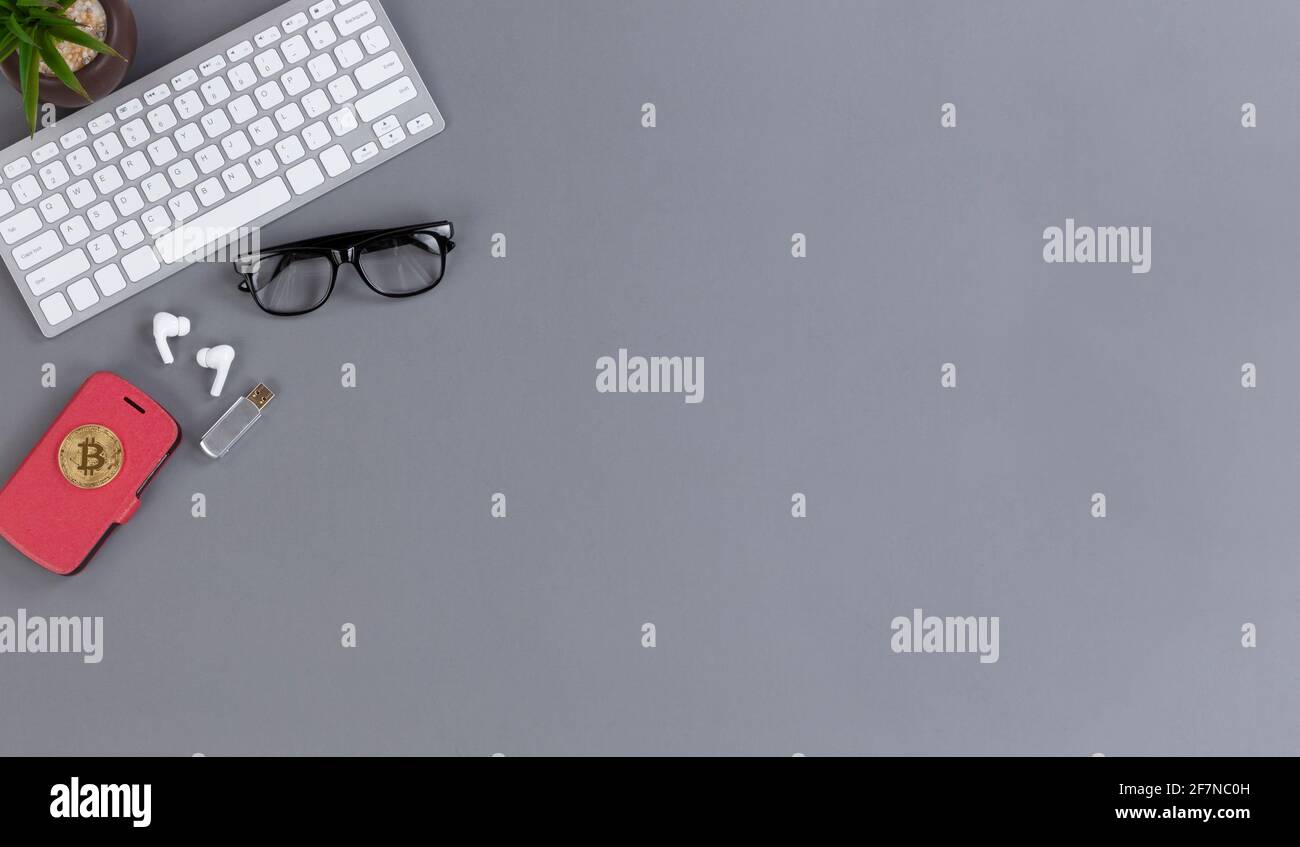 Bureau sans fil mobile avec smartphone, bitcoin, clavier d'ordinateur, clé USB, plante pour bébé et lunettes de lecture Banque D'Images