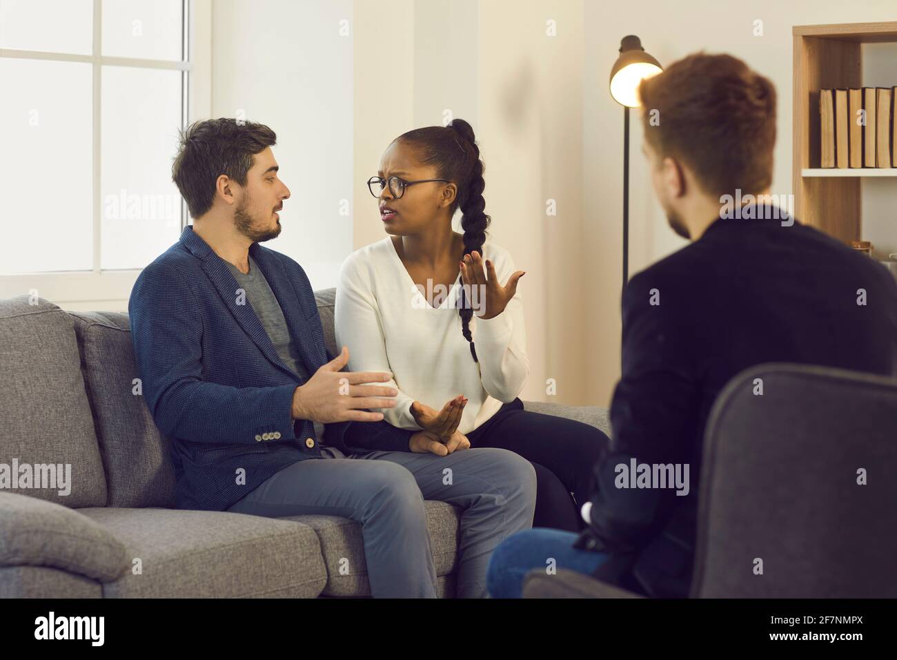 Couple éprouvant des problèmes de relation se blâmant les uns les autres pendant la séance de thérapie Banque D'Images