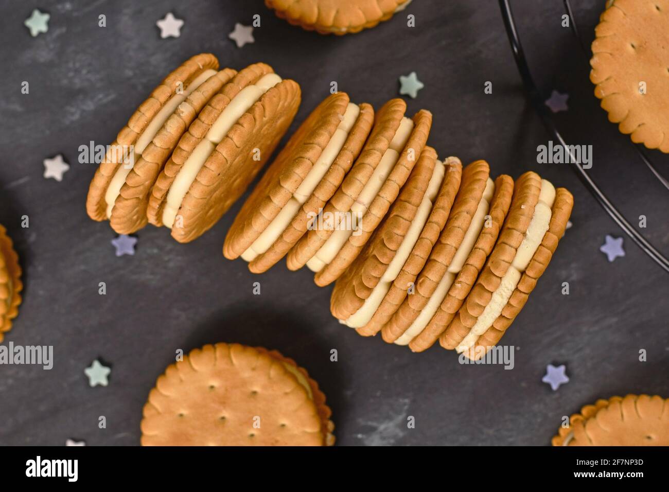 Biscuits sandwich à la crème avec saupoudrés sur fond sombre Banque D'Images